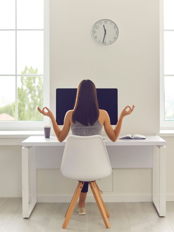 ambiance propice à la concentration avec une femme qui médite sur son siège de bureau / visiondeco